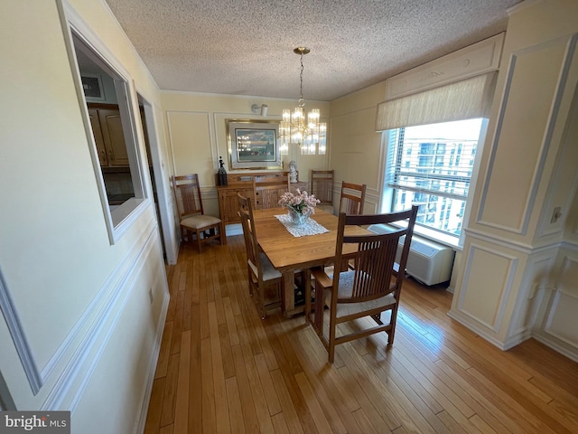 666 W Germantown Pike Unit 1721, Plymouth Meeting, PA 19462 - dining area with a decorative wall, a chandelier, a textured ceiling, and light wood-style flooring