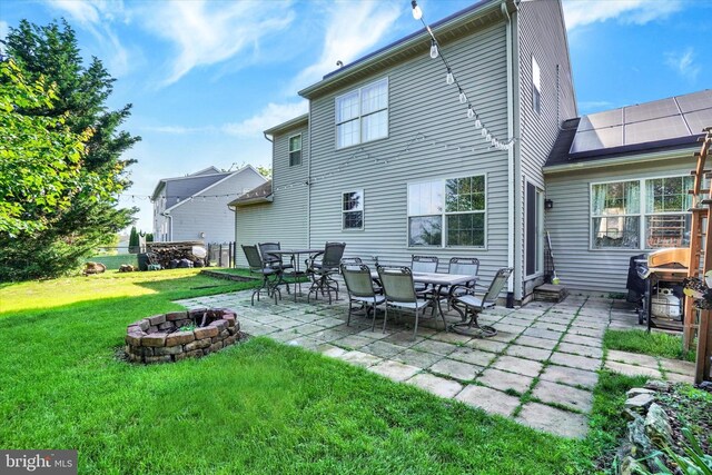 3758 Kimberly Ln, Dover, PA 17315 - back of house with a fire pit, a patio, a lawn, and roof mounted solar panels