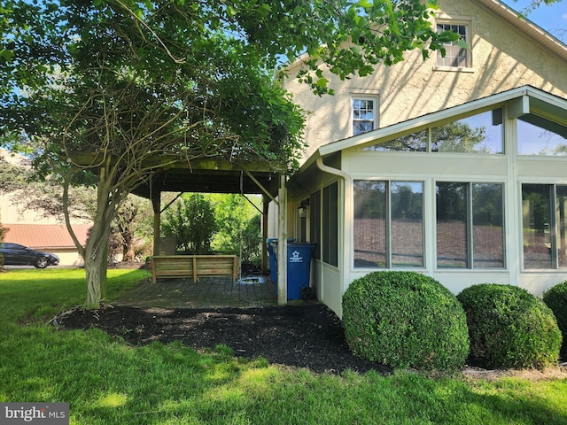 4560 Bossler Rd, Elizabethtown, PA 17022 - view of home's exterior with a sunroom, stucco siding, and a lawn