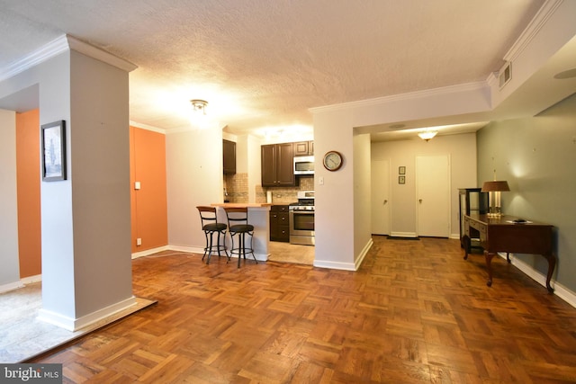 80 W Baltimore Ave, Lansdowne, PA 19050 - kitchen with appliances with stainless steel finishes, light countertops, a kitchen breakfast bar, baseboards, and ornamental molding