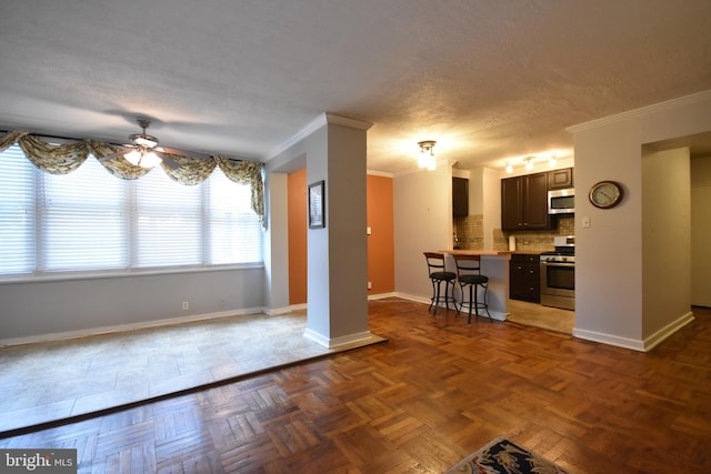 80 W Baltimore Ave, Lansdowne, PA 19050 - kitchen featuring appliances with stainless steel finishes, ornamental molding, a ceiling fan, a kitchen bar, and baseboards