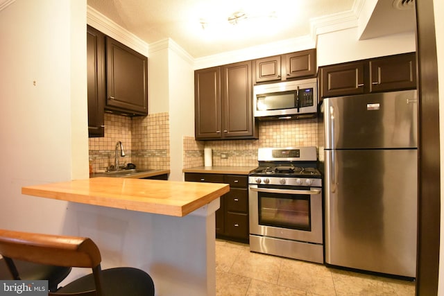 80 W Baltimore Ave, Lansdowne, PA 19050 - kitchen with appliances with stainless steel finishes, a sink, wooden counters, crown molding, and backsplash