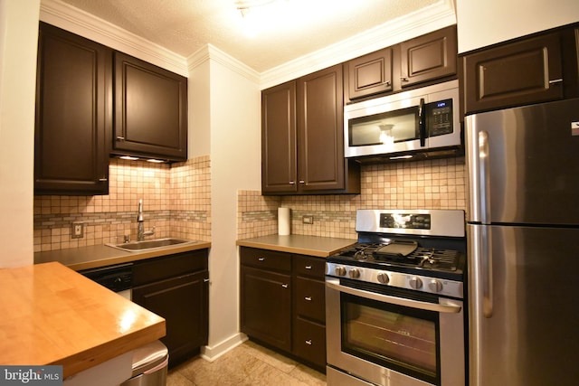 80 W Baltimore Ave, Lansdowne, PA 19050 - kitchen featuring stainless steel appliances, a sink, crown molding, dark brown cabinetry, and backsplash