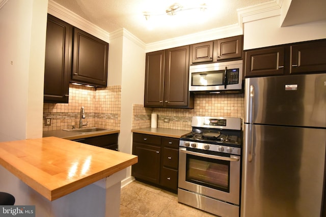 80 W Baltimore Ave, Lansdowne, PA 19050 - kitchen with stainless steel appliances, a sink, butcher block counters, dark brown cabinets, and crown molding