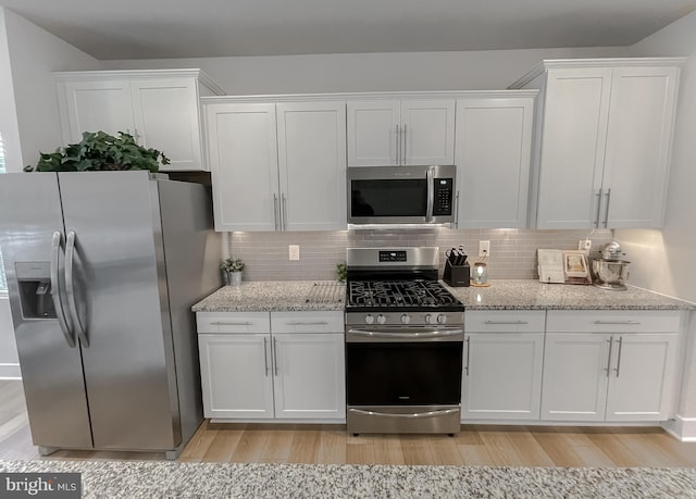 45375 Concord Way, California, MD 20619 - kitchen featuring appliances with stainless steel finishes, light wood-style flooring, white cabinetry, and backsplash