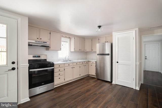 218 Elizabeth St, Bordentown, NJ 08505 - kitchen with appliances with stainless steel finishes, under cabinet range hood, light countertops, a sink, and dark wood-type flooring