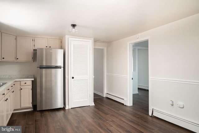 218 Elizabeth St, Bordentown, NJ 08505 - kitchen featuring freestanding refrigerator, a baseboard heating unit, light countertops, and dark wood-style floors