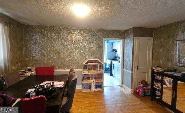 6517 Montour St, Philadelphia, PA 19111 - dining area featuring wood finished floors, washer and dryer, wallpapered walls, and a textured ceiling