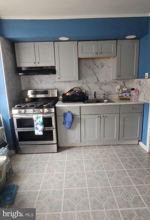 6517 Montour St, Philadelphia, PA 19111 - kitchen with range with two ovens, a sink, under cabinet range hood, gray cabinetry, and tasteful backsplash
