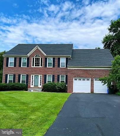 1176 Bandy Run Rd, Herndon, VA 20170 - colonial inspired home with asphalt driveway, a front lawn, a garage, and brick siding