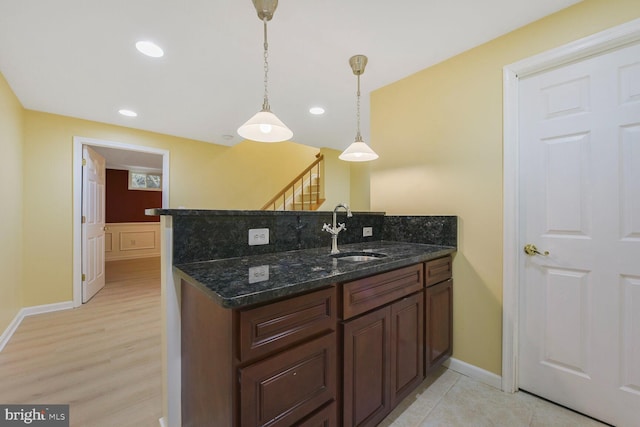 1176 Bandy Run Rd, Herndon, VA 20170 - kitchen featuring a sink, pendant lighting, baseboards, a peninsula, and dark stone countertops