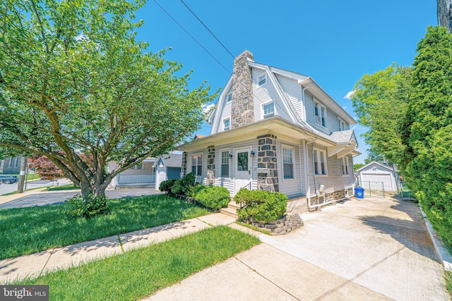 27 Shelbourne Rd, Havertown, PA 19083 - view of front of home with an outbuilding, a detached garage, concrete driveway, a chimney, and a gambrel roof