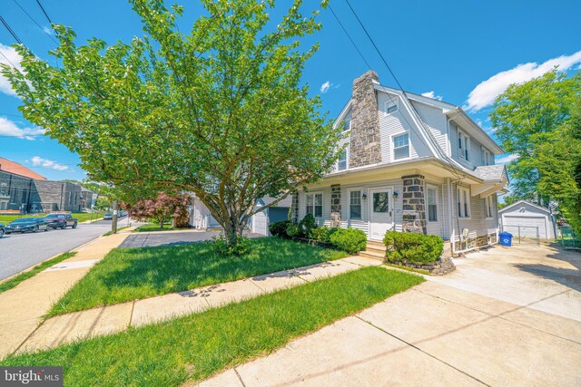 27 Shelbourne Rd, Havertown, PA 19083 - view of front facade with an outbuilding, a chimney, a front yard, and concrete driveway