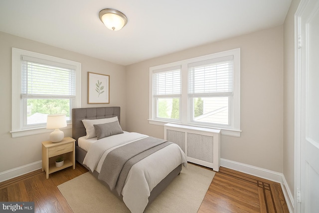 27 Shelbourne Rd, Havertown, PA 19083 - bedroom with radiator heating unit, multiple windows, baseboards, and wood finished floors