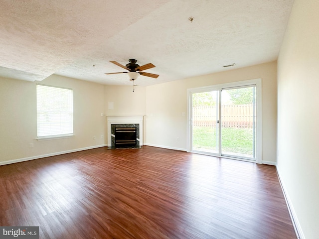 22565 Upper Kells Ln, Great Mills, MD 20634 - unfurnished living room with a textured ceiling, dark wood-style flooring, ceiling fan, baseboards, and a premium fireplace