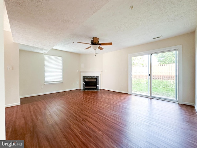 22565 Upper Kells Ln, Great Mills, MD 20634 - unfurnished living room with a textured ceiling, ceiling fan, dark wood-style flooring, a high end fireplace, and baseboards