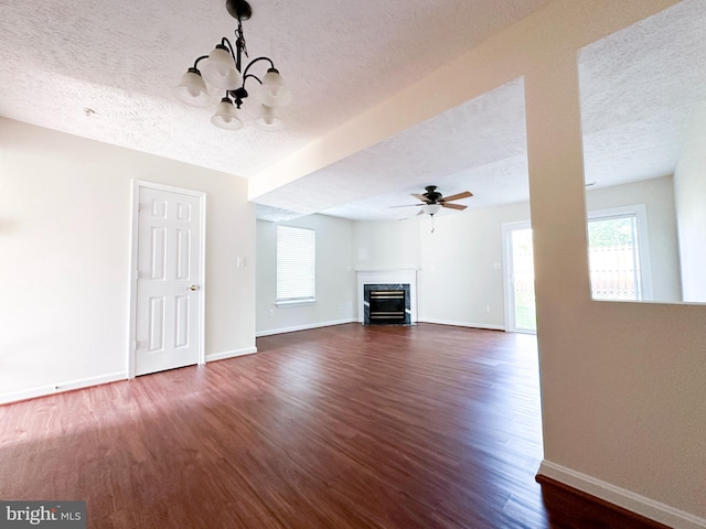 22565 Upper Kells Ln, Great Mills, MD 20634 - unfurnished living room featuring a chandelier, a textured ceiling, a fireplace with flush hearth, dark wood-style floors, and baseboards