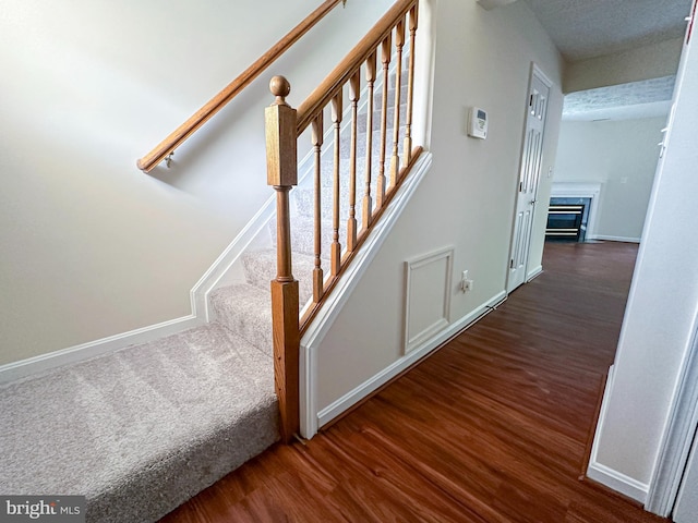 22565 Upper Kells Ln, Great Mills, MD 20634 - staircase featuring wood finished floors, baseboards, and a glass covered fireplace