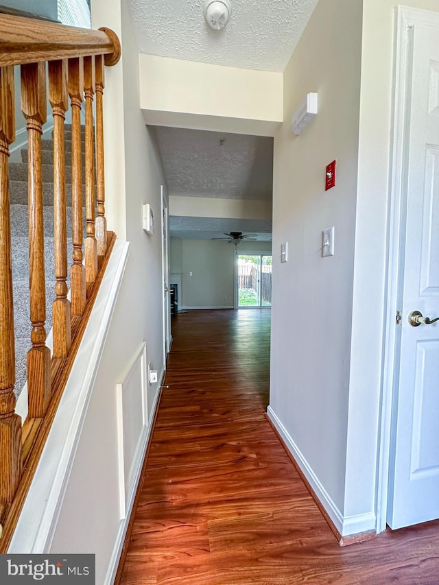 22565 Upper Kells Ln, Great Mills, MD 20634 - hall with wood finished floors, baseboards, a textured ceiling, and stairway
