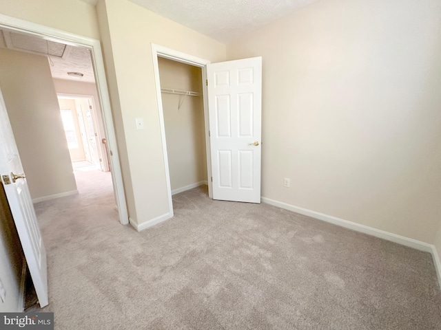 22565 Upper Kells Ln, Great Mills, MD 20634 - unfurnished bedroom with light colored carpet, attic access, baseboards, a closet, and a textured ceiling