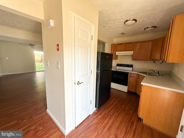 22565 Upper Kells Ln, Great Mills, MD 20634 - kitchen with electric range, freestanding refrigerator, under cabinet range hood, dark wood finished floors, and a textured ceiling
