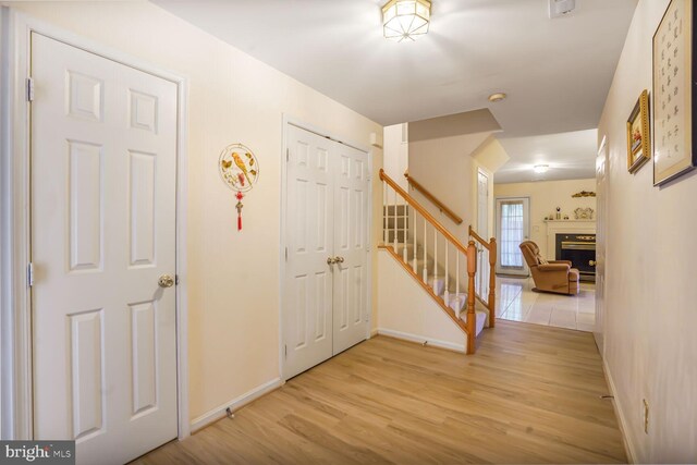 4057 Glostonbury Way, Fairfax, VA 22030 - foyer with stairway, light wood-type flooring, a glass covered fireplace, and baseboards