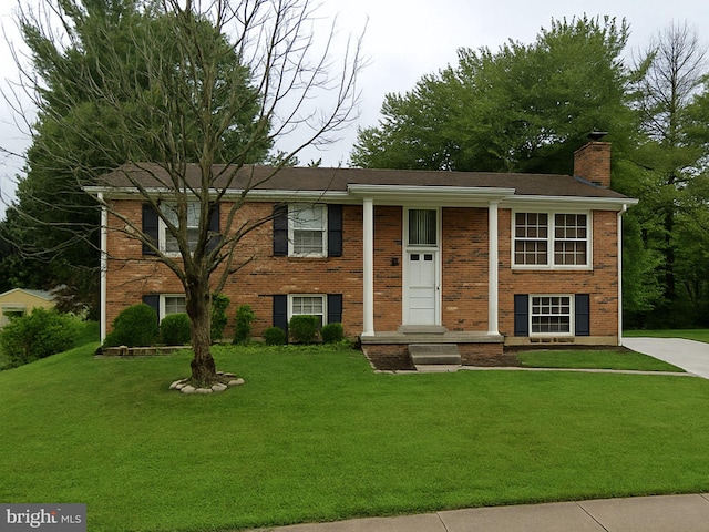 13708 Gilbert Rd, Woodbridge, VA 22193 - split foyer home featuring a chimney, a front yard, and brick siding
