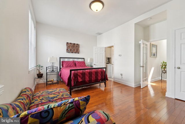 14 E Preston St, Baltimore, MD 21202 - bedroom featuring hardwood / wood-style floors, washer / clothes dryer, and baseboards
