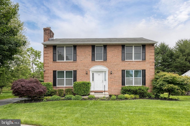 12 Dandelion Ct, Owings Mills, MD 21117 - colonial-style house featuring a chimney, brick siding, and a front lawn