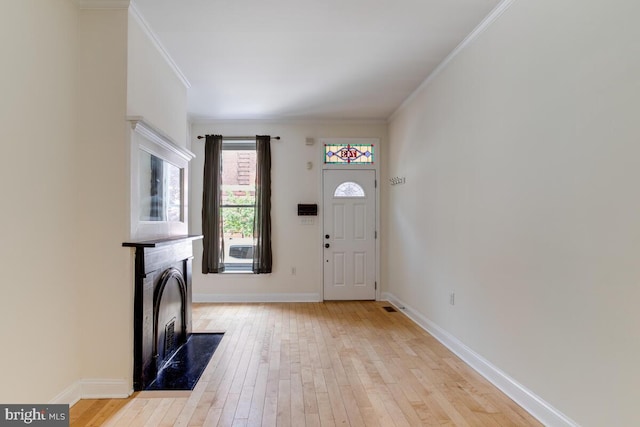 743 W Cross St, Baltimore, MD 21230 - foyer featuring light wood-style flooring, a fireplace, and crown molding
