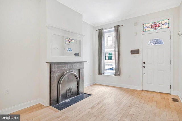743 W Cross St, Baltimore, MD 21230 - entrance foyer with hardwood / wood-style flooring, a fireplace with flush hearth, and ornamental molding