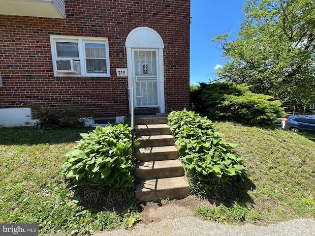 719 E 25th St, Chester, PA 19013 - view of exterior entry featuring brick siding, a yard, and cooling unit