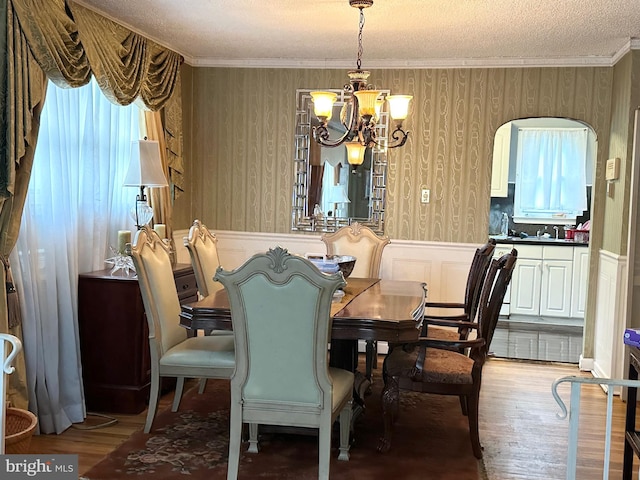 719 E 25th St, Chester, PA 19013 - dining space with a chandelier, healthy amount of natural light, a wainscoted wall, wood finished floors, and crown molding