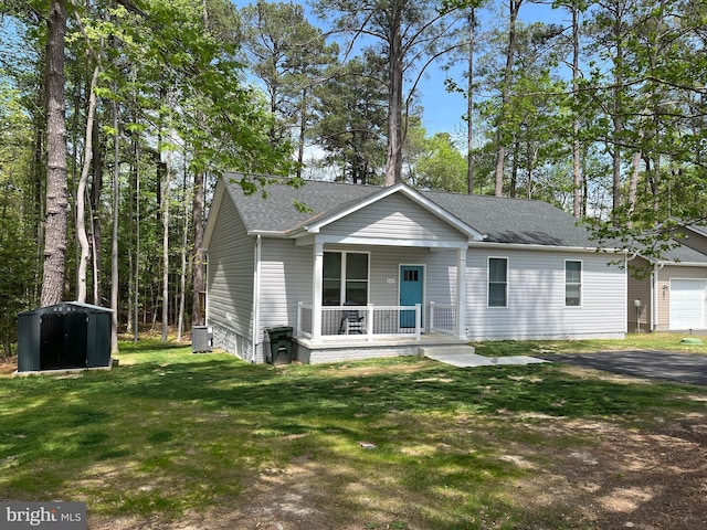 520 Glebe Rd S, Montross, VA 22520 - ranch-style home featuring covered porch, a shingled roof, a front lawn, central AC unit, and an outdoor structure