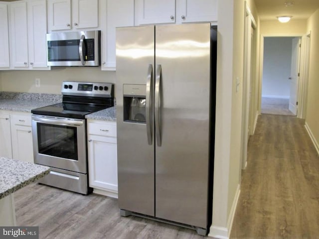 520 Glebe Rd S, Montross, VA 22520 - kitchen with stainless steel appliances, light wood finished floors, white cabinetry, and light stone counters