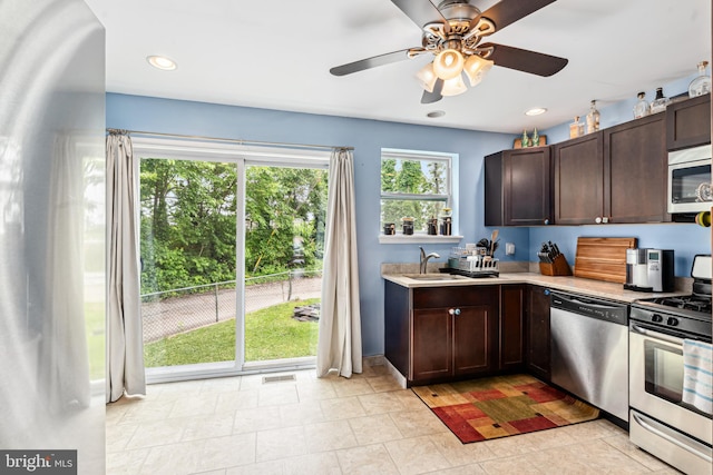 656 48th St, Baltimore, MD 21224 - kitchen featuring stainless steel appliances, light countertops, dark brown cabinetry, a sink, and ceiling fan