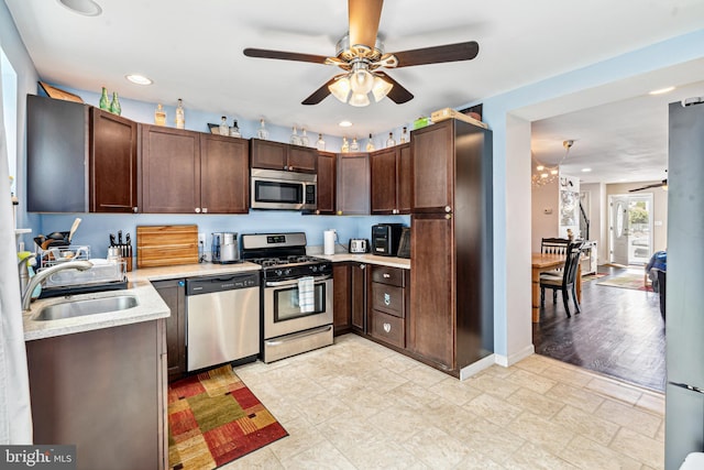 656 48th St, Baltimore, MD 21224 - kitchen with stainless steel appliances, a ceiling fan, a sink, light countertops, and dark brown cabinetry