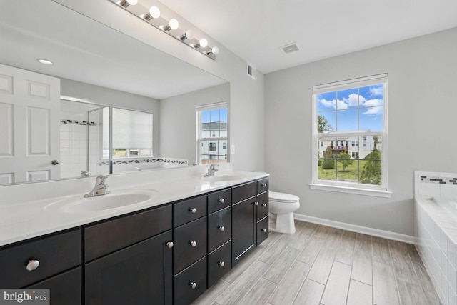 11 Worsham Ln, Fredericksburg, VA 22405 - bathroom with double vanity, baseboards, toilet, a relaxing tiled tub, and tiled shower