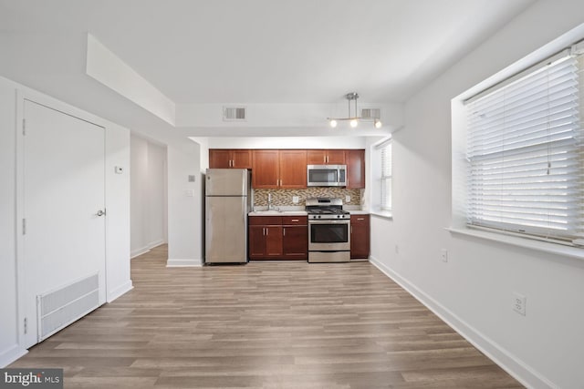 2900 Pomeroy Rd SE Unit 203, Washington, DC 20020 - kitchen featuring appliances with stainless steel finishes, decorative backsplash, light countertops, light wood finished floors, and baseboards