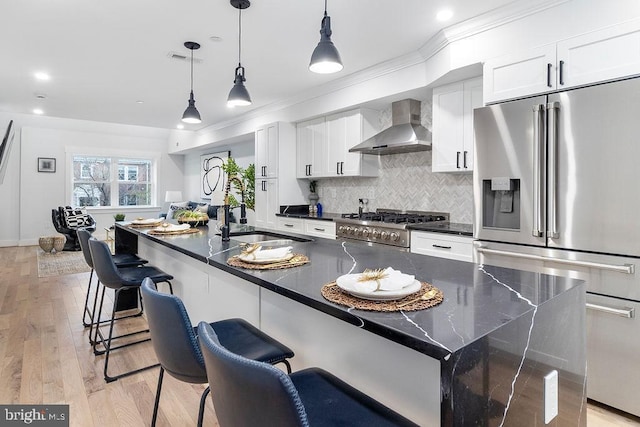 1242 Meigs Pl NE Unit C, Washington, DC 20002 - kitchen featuring stainless steel fridge, wall chimney range hood, a sink, stove, and white cabinetry