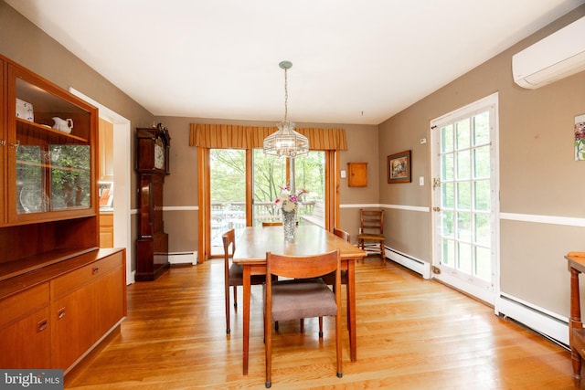337 Greene Rd, Berwyn, PA 19312 - dining area with a wall mounted AC, a baseboard radiator, a chandelier, light wood-type flooring, and healthy amount of natural light