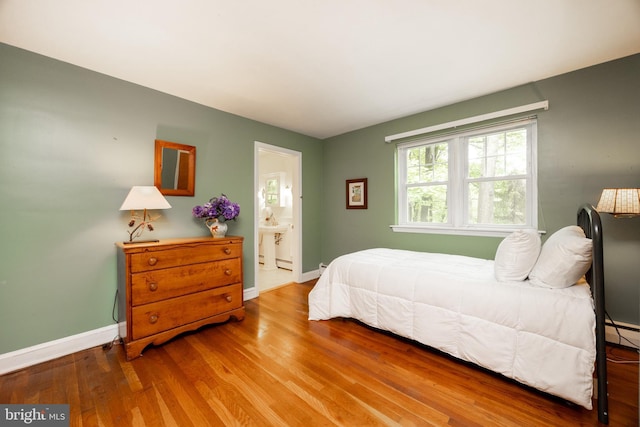 337 Greene Rd, Berwyn, PA 19312 - bedroom featuring baseboards, wood finished floors, ensuite bath, and a baseboard radiator