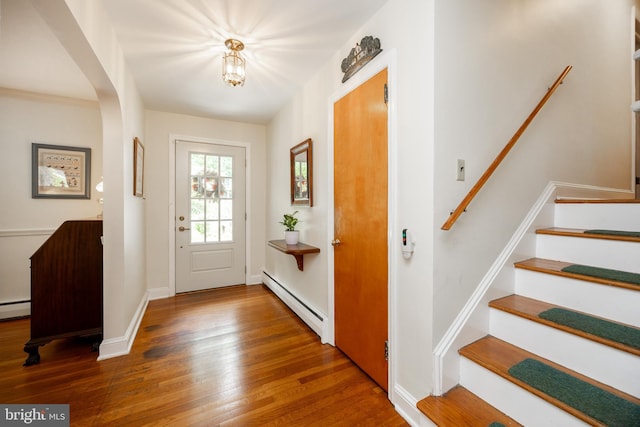337 Greene Rd, Berwyn, PA 19312 - entryway featuring a baseboard heating unit, wood finished floors, stairs, and arched walkways