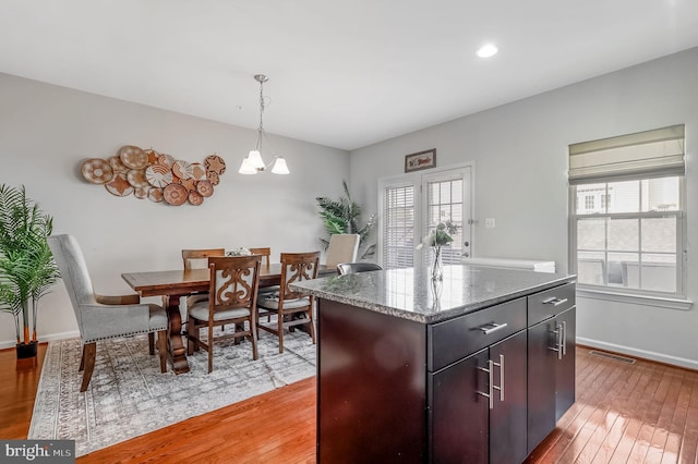 2620 Egret Way, Frederick, MD 21701 - kitchen with light wood-style flooring, baseboards, pendant lighting, a center island, and dark stone countertops