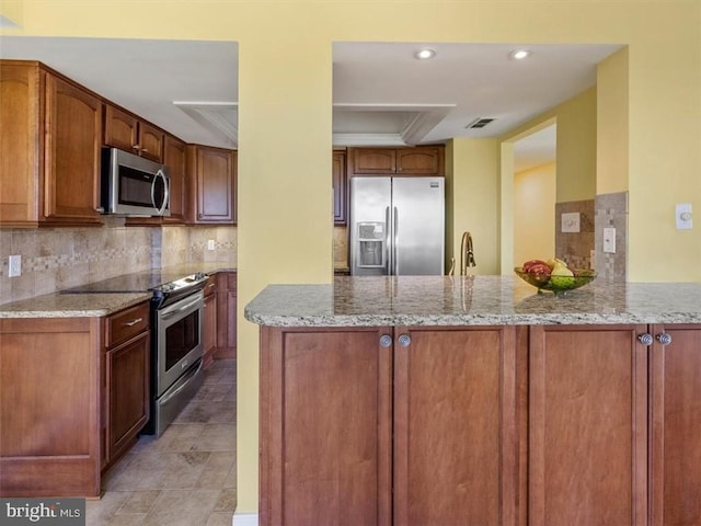 2956 Hathaway Rd Unit 1205, Richmond, VA 23225 - kitchen featuring stainless steel appliances, light stone counters, a peninsula, decorative backsplash, and a tray ceiling