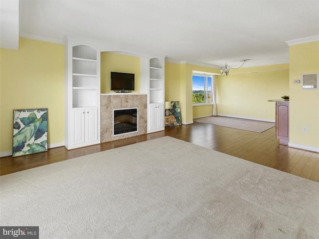 2956 Hathaway Rd Unit 1205, Richmond, VA 23225 - unfurnished living room with baseboards, crown molding, a tiled fireplace, wood finished floors, and built in features