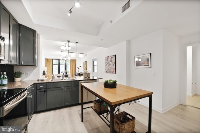 400 Massachusetts Ave NW Unit 223, Washington, DC 20001 - kitchen featuring stainless steel appliances, a raised ceiling, a peninsula, and light wood-type flooring