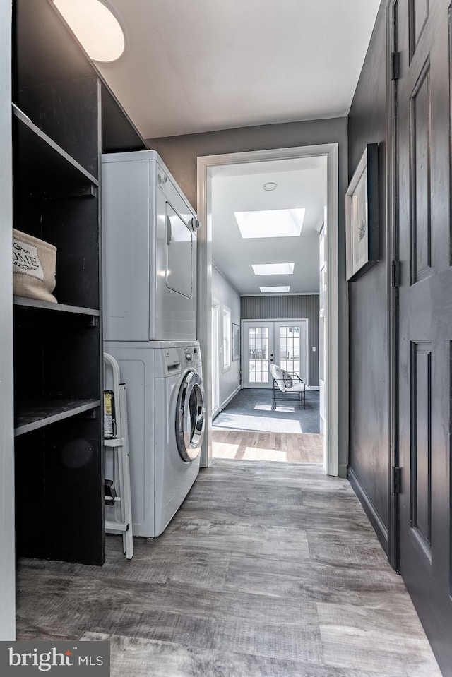 5634 8th Rd N, Arlington, VA 22205 - washroom with stacked washer and clothes dryer, a skylight, and wood finished floors