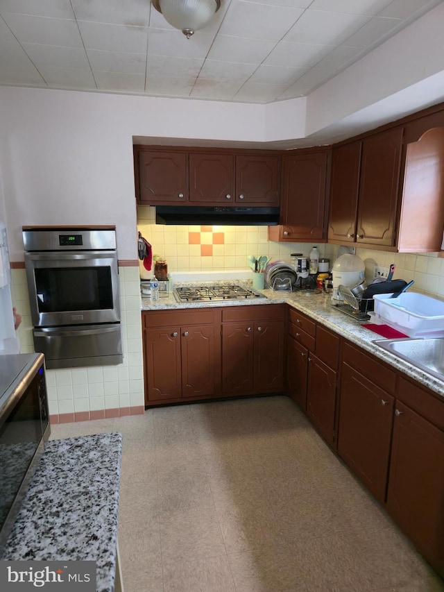 9618 Hoff St, Philadelphia, PA 19115 - kitchen featuring appliances with stainless steel finishes, a warming drawer, under cabinet range hood, a sink, and light stone counters