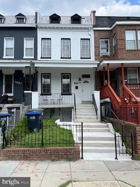 1935 4th St NE, Washington, DC 20002 - townhome / multi-family property with stairway, covered porch, a fenced front yard, and cooling unit